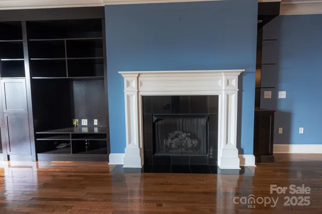 a kitchen with granite countertop a refrigerator and a wooden floor