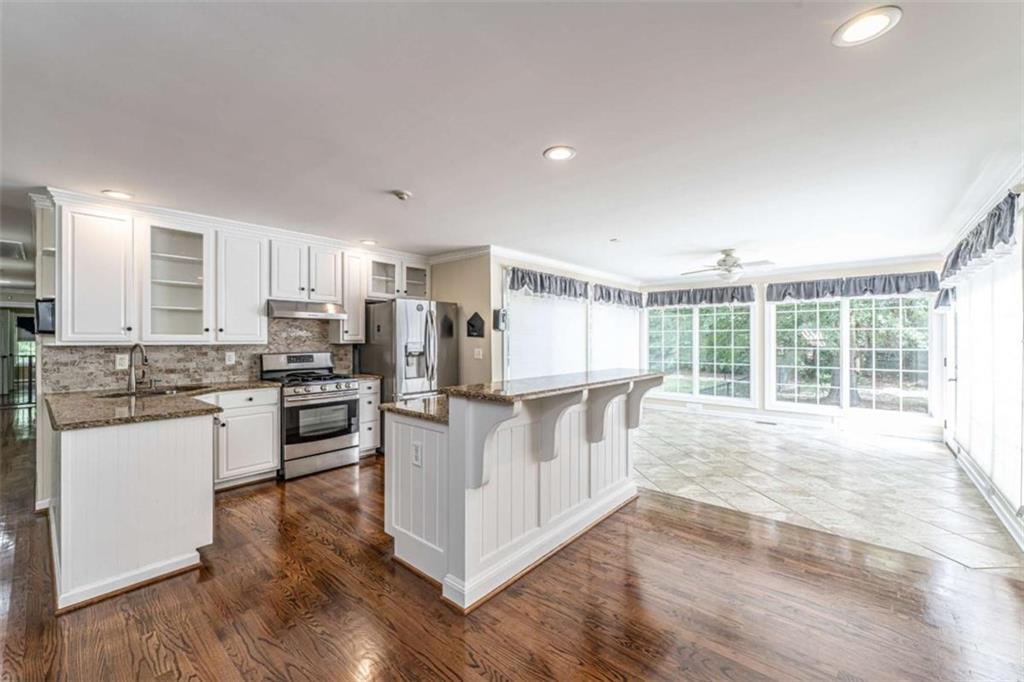 45 Wildflower Road Northeast Rome, GA 30161 - Photo 13 of 36 a large white kitchen with wooden floor and stainless steel appliances
