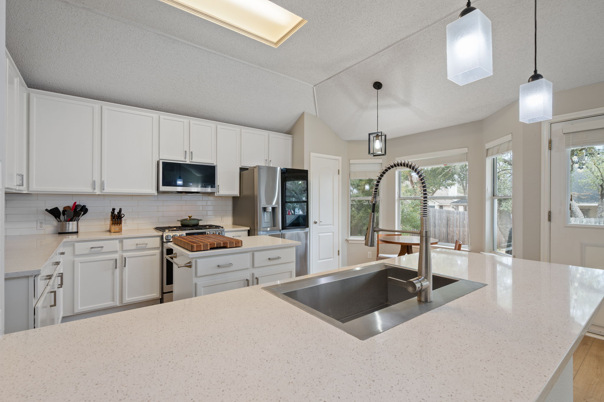 8509 Moose Cove Austin, TX 78749 - Photo 11 of 40 a kitchen with stainless steel appliances a sink a stove a refrigerator cabinets and living room view