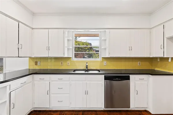 a kitchen with granite countertop a sink and cabinets