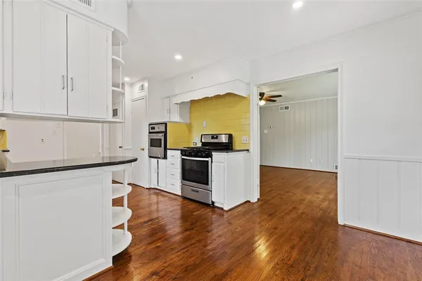 a kitchen with granite countertop a refrigerator and a stove top oven