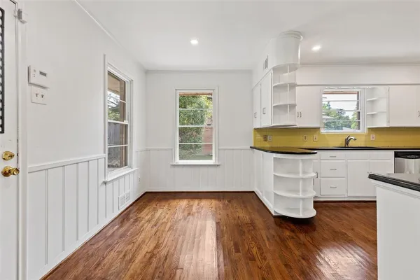 a view of kitchen with wooden floors and white walls