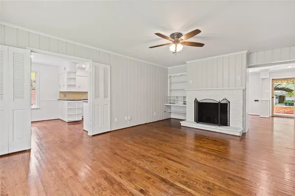 a view of a livingroom with wooden floor and a fireplace