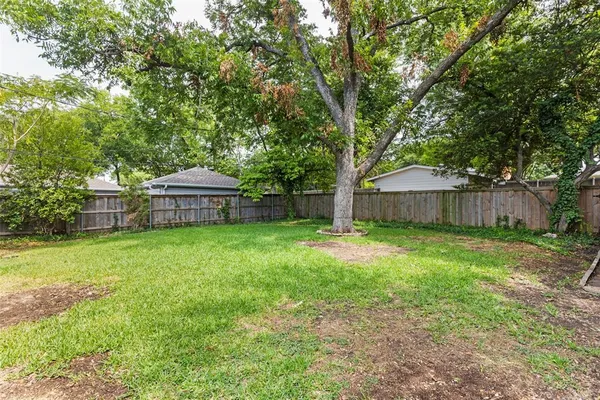 a front view of a house with yard and tree