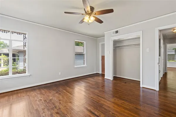 a view of an empty room with window and wooden floor