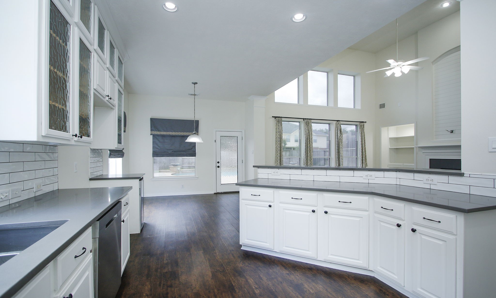 1210 Berwick Manor Court Spring, TX 77379 - Photo 25 of 50 a kitchen with granite countertop a stove a sink and white cabinets with wooden floor