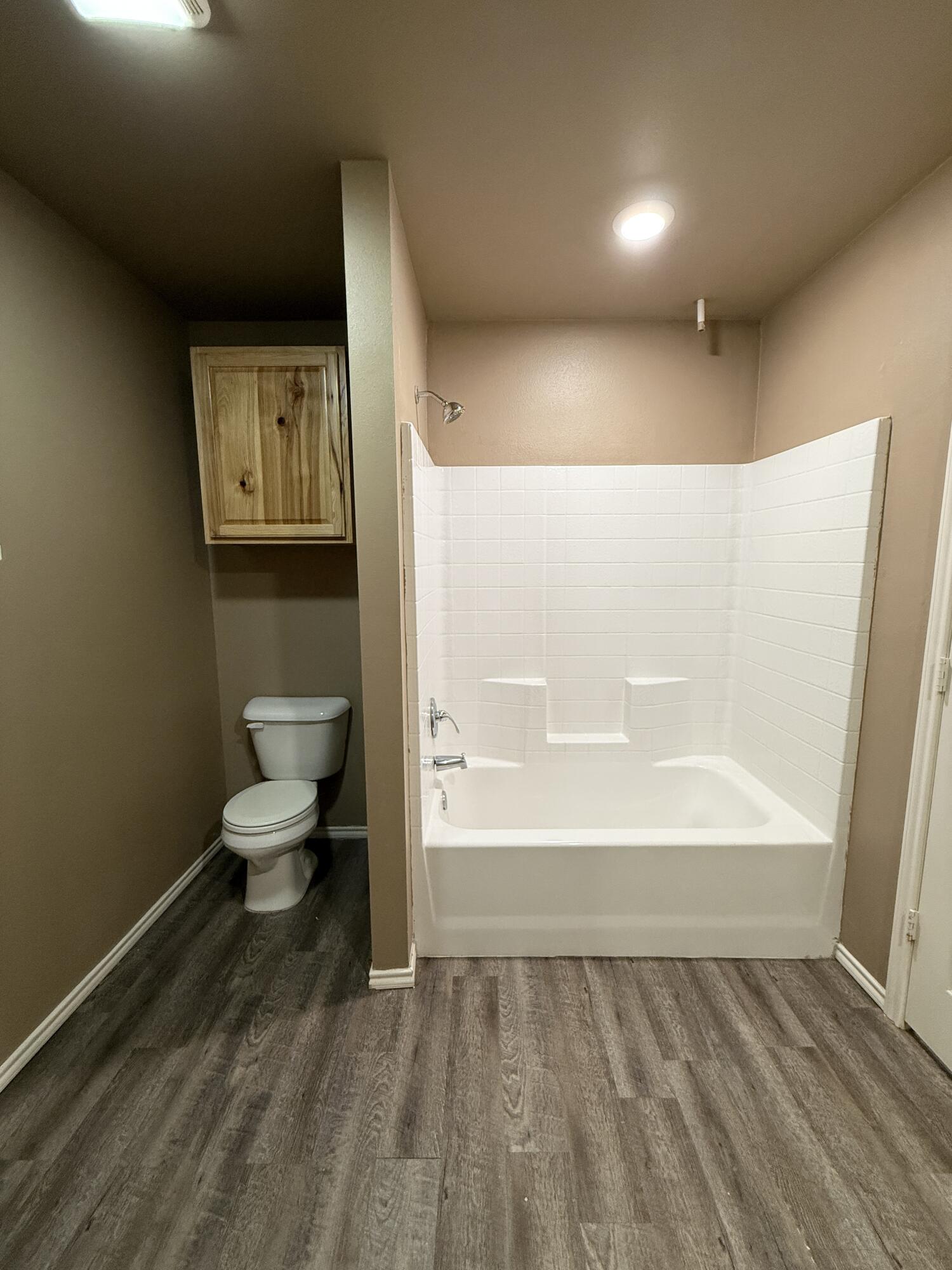524 46th Street, Unit B Lubbock, TX 79404 - Photo 12 of 14 a bathroom with a toilet and a shower