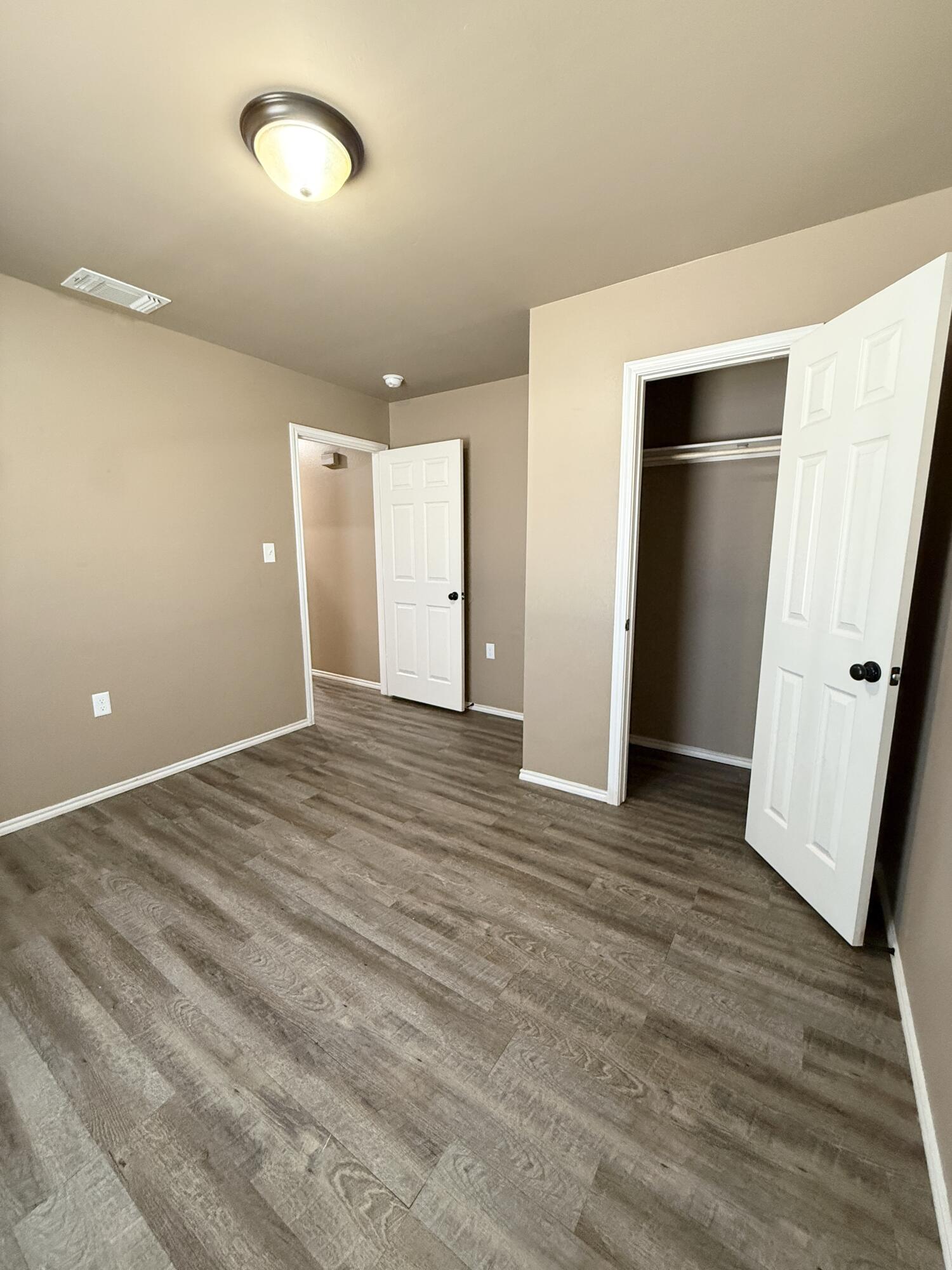 524 46th Street, Unit B Lubbock, TX 79404 - Photo 14 of 14 an empty room with wooden floor and white doors