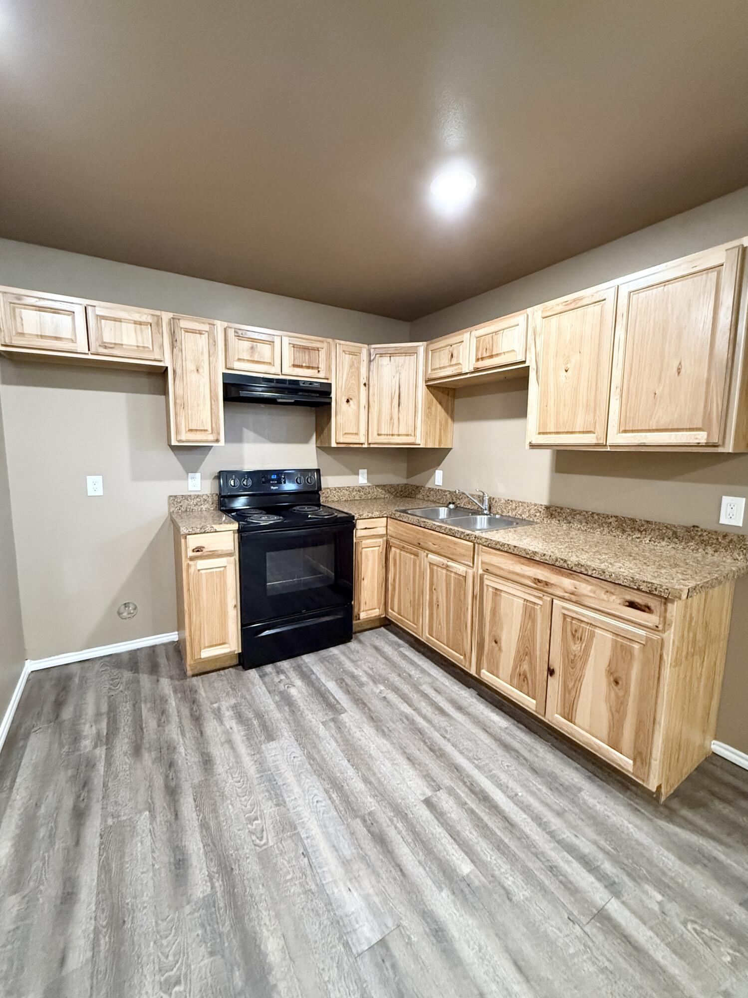 524 46th Street, Unit B Lubbock, TX 79404 - Photo 3 of 14 a kitchen with stainless steel appliances granite countertop a stove a sink and a microwave