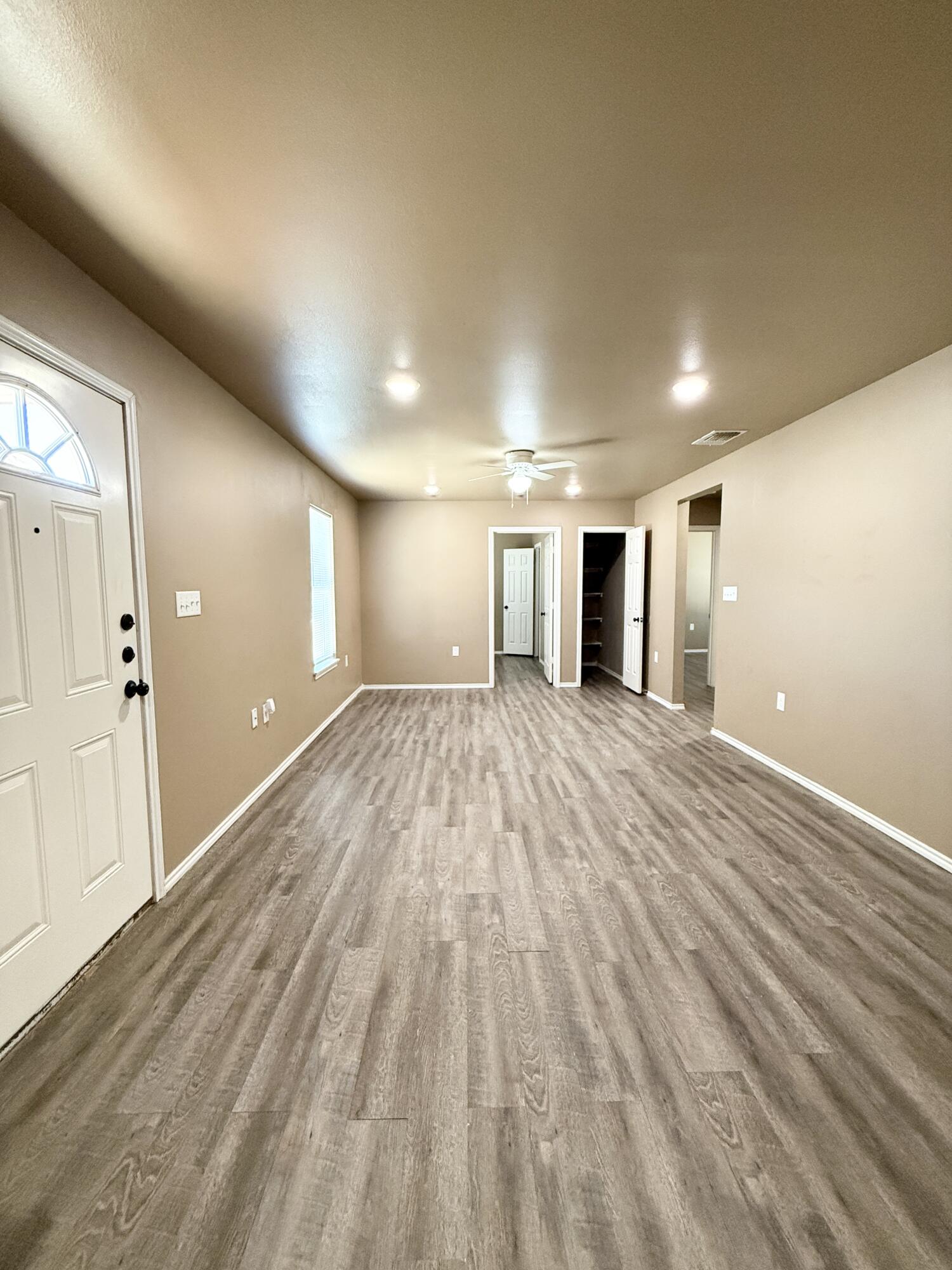 524 46th Street, Unit B Lubbock, TX 79404 - Photo 4 of 14 an empty room with wooden floor and windows