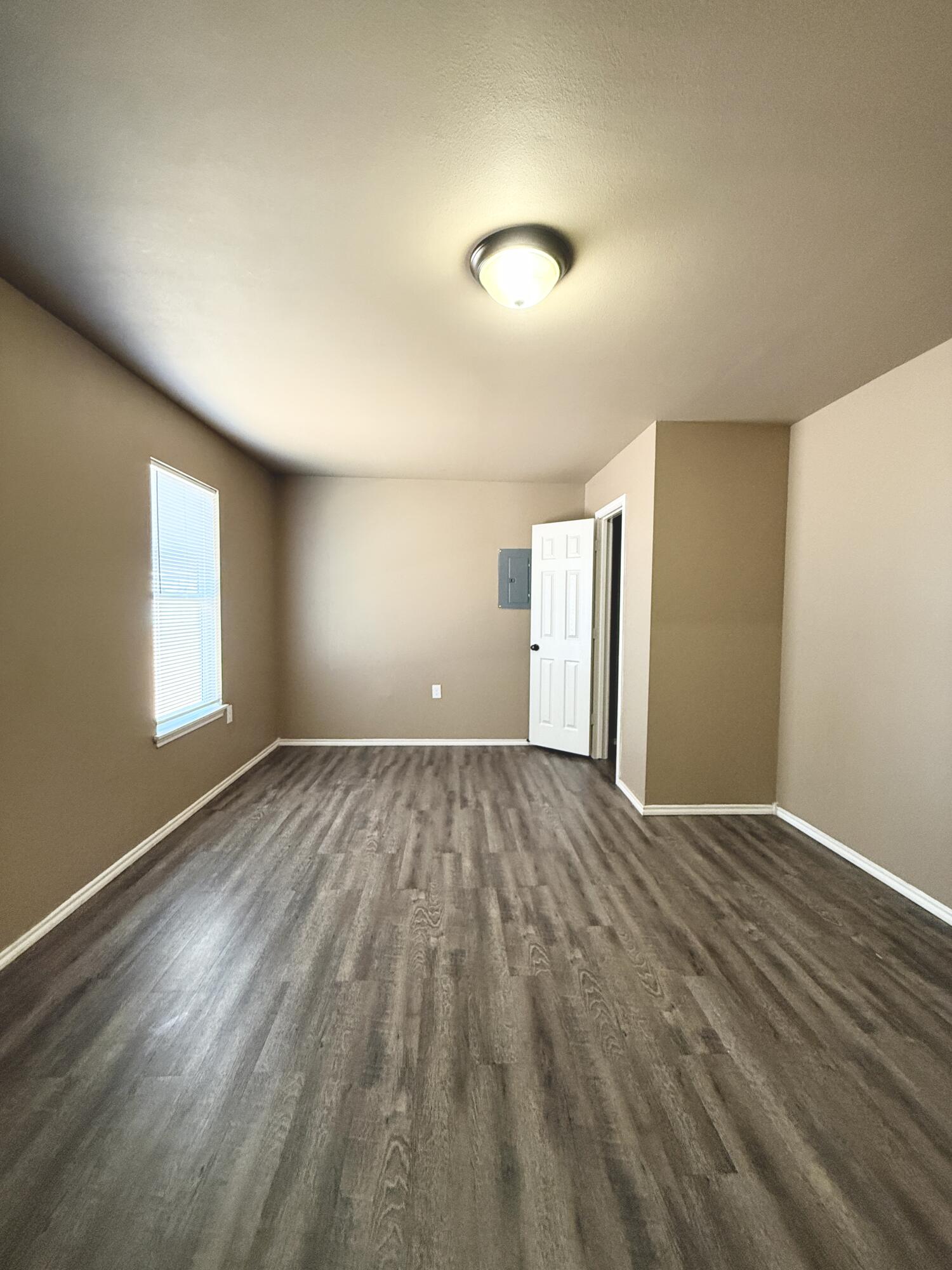 524 46th Street, Unit B Lubbock, TX 79404 - Photo 8 of 14 wooden floor in an empty room with a window