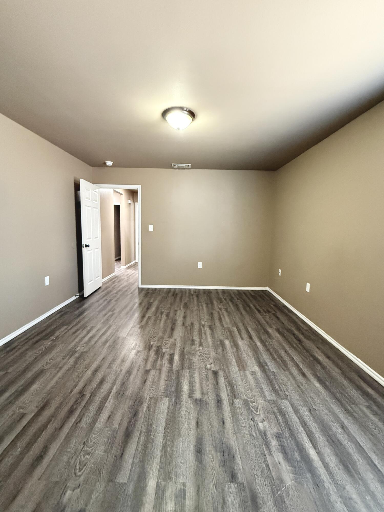 524 46th Street, Unit B Lubbock, TX 79404 - Photo 9 of 14 an empty room with wooden floor and windows