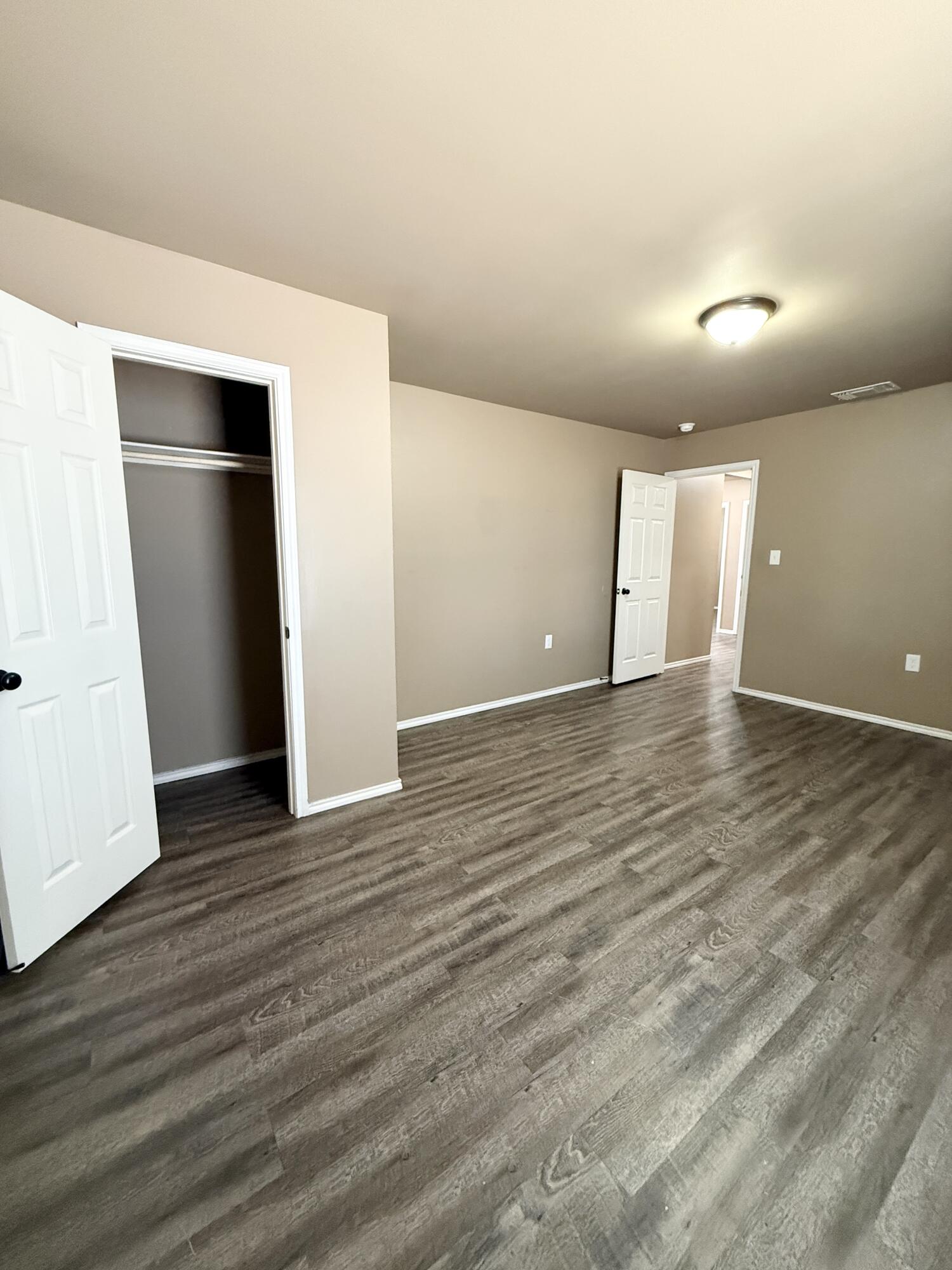 524 46th Street, Unit B Lubbock, TX 79404 - Photo 10 of 14 an empty room with wooden floor and closet