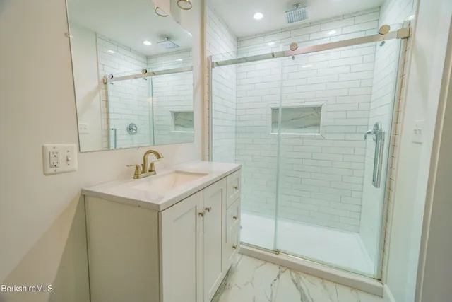 a bathroom with a shower sink and mirror