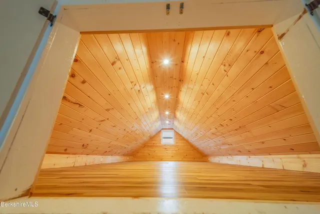 a bed room with a bed window and potted plant on the dresser