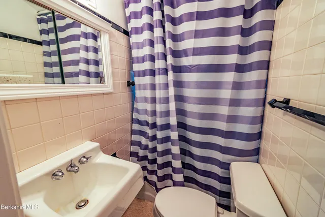 a bed sitting in a bedroom next to a window with a chandelier