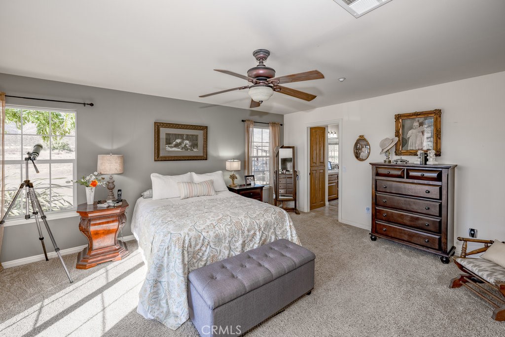 34554 Koontz Road Agua Dulce, CA 91390 - Photo 11 of 33 a spacious bedroom with a bed and a chandelier