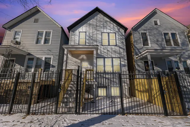 a view of a house with a small yard and wooden fence