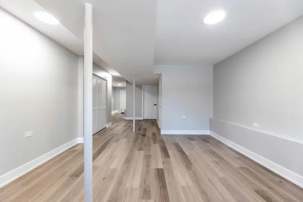 a view of a big room with wooden floor and windows