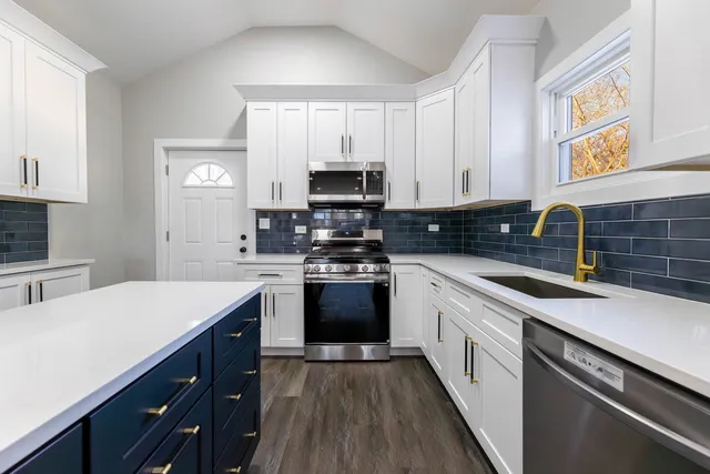 a kitchen with a sink stove top oven and cabinets