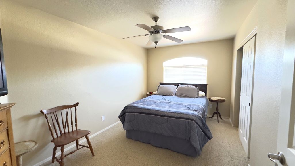 3316 Producers Mine Road Kingman, AZ 86401 - Photo 30 of 35 Carpeted room featuring a ceiling fan with integrated lighting, an arched window.