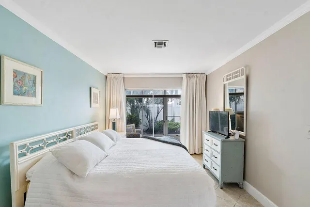 a bedroom with a bed and a flat tv screen next to a window