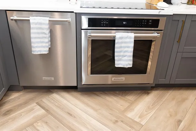 a metallic refrigerator freezer sitting in a kitchen