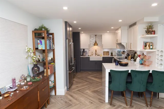 a kitchen with a dining table chairs and refrigerator