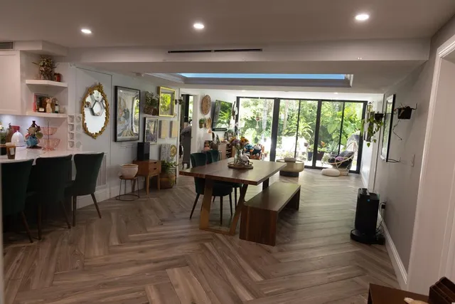 a living room with furniture a large window and wooden floor