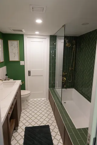 a bathroom with a granite countertop sink a toilet and shower