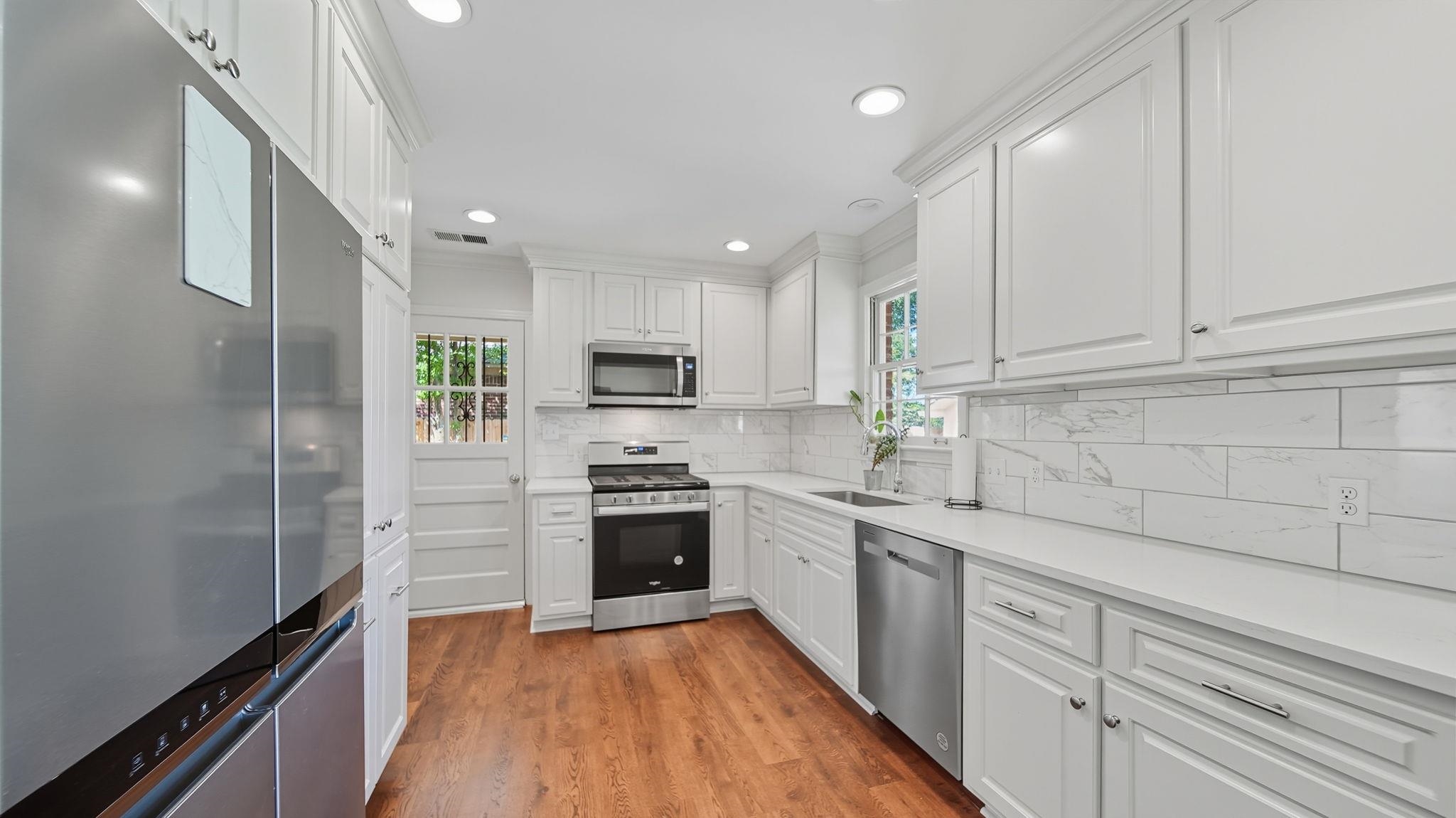 678 Moss Road Memphis, TN 38117 - Photo 23 of 33 Kitchen featuring appliances with stainless steel finishes, white cabinetry, light wood-type flooring, plenty of natural light, and recessed lighting