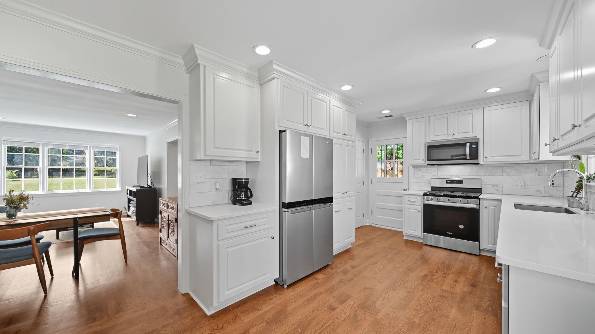 678 Moss Road Memphis, TN 38117 - Photo 26 of 33 Kitchen with decorative backsplash, stainless steel appliances, white cabinets, light wood-style flooring, and recessed lighting