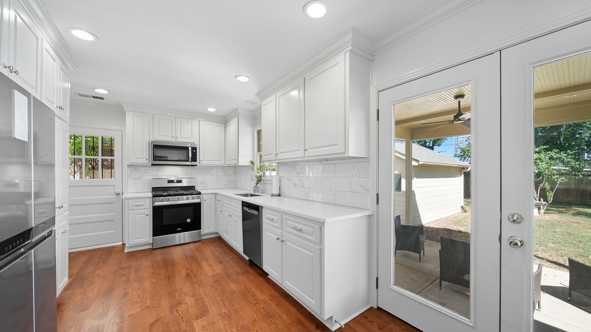 678 Moss Road Memphis, TN 38117 - Photo 7 of 33 Kitchen with white cabinets, dark wood-style floors, appliances with stainless steel finishes, backsplash, and recessed lighting