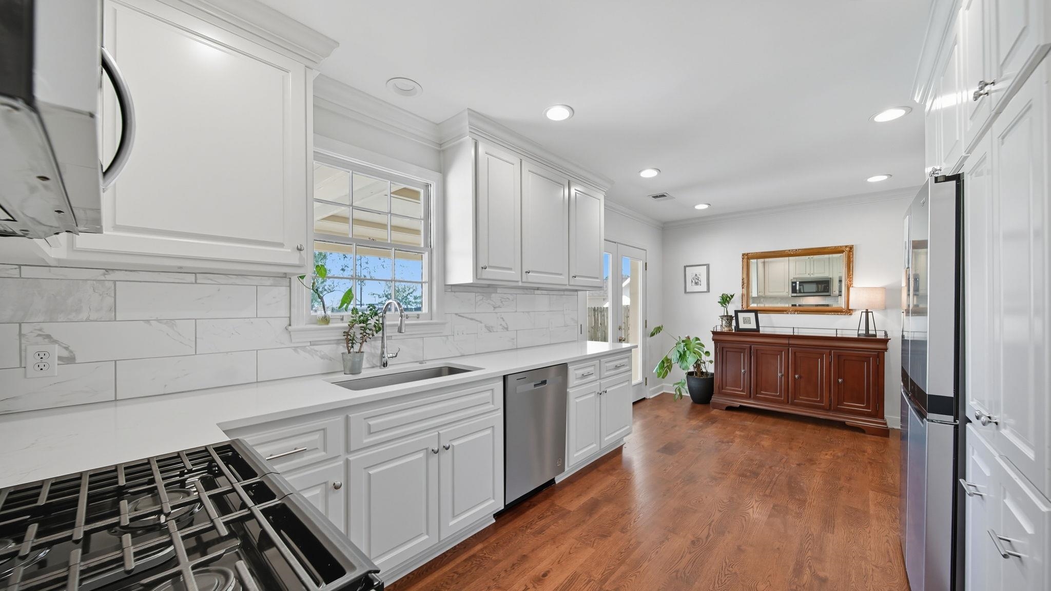 678 Moss Road Memphis, TN 38117 - Photo 8 of 33 Kitchen featuring white cabinets, dark wood-type flooring, stainless steel appliances, ornamental molding, and recessed lighting