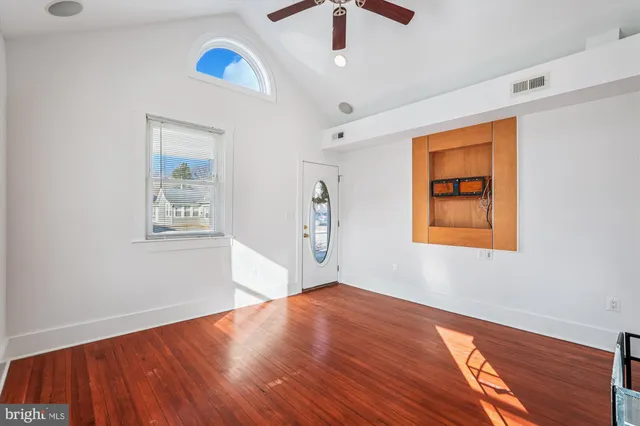a view of empty room with wooden floor