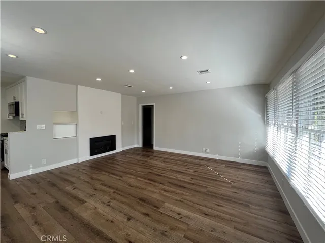 an empty room with wooden floor and fireplace