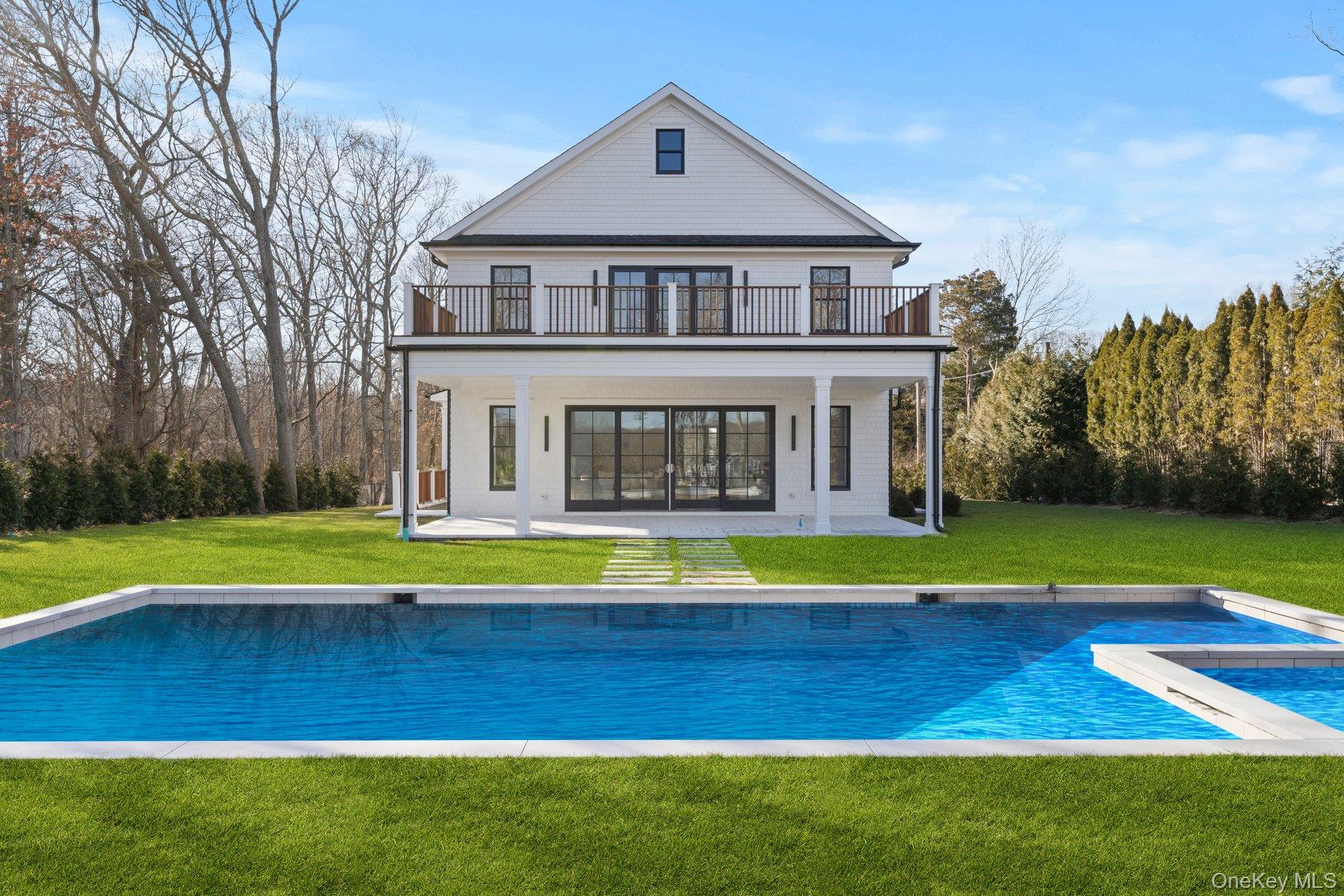 2590 Cox Neck Road Mattituck, NY 11952 - Photo 44 of 50 Back of property with a lawn, a patio area, and an outdoor pool