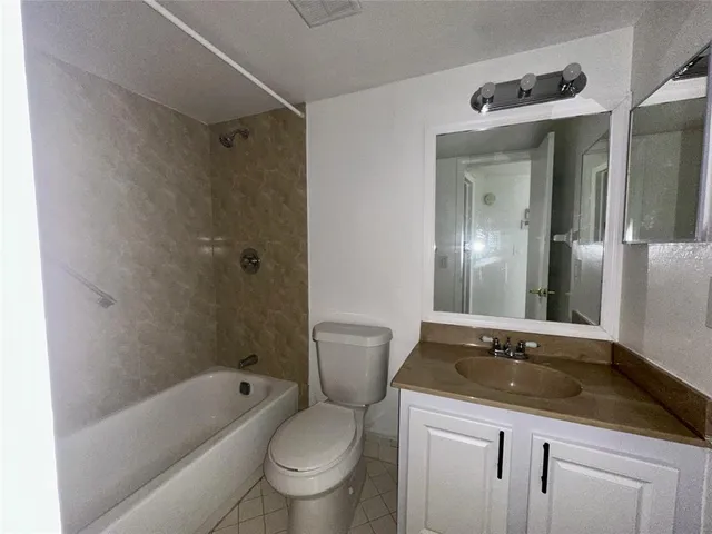 a bathroom with a granite countertop sink a toilet and shower