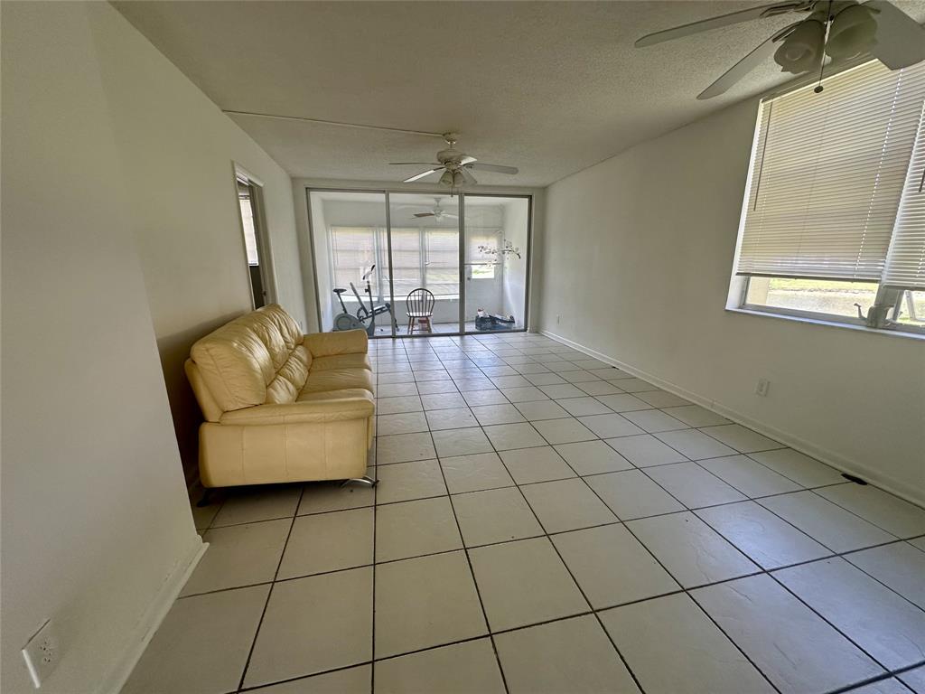 5980 Northwest 64th Avenue, Unit 112 Tamarac, FL 33319 - Photo 2 of 13 a living room with furniture and a floor to ceiling window