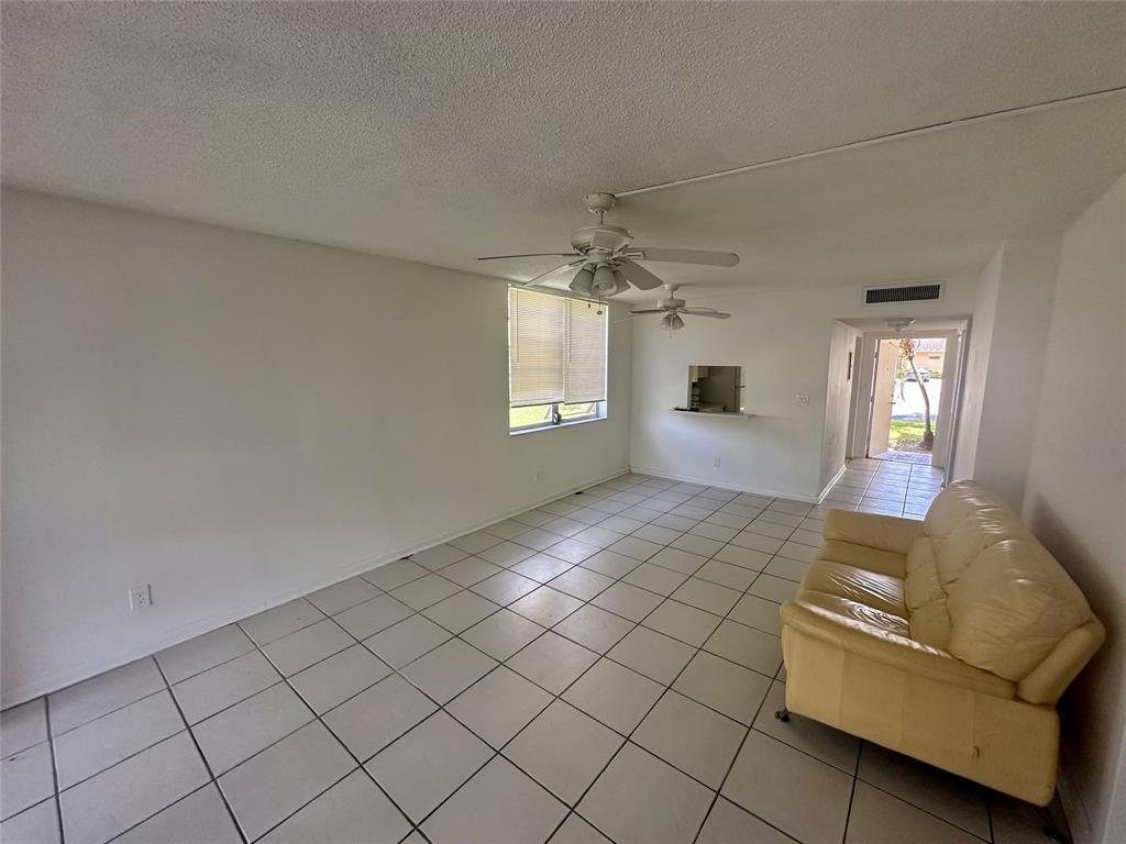 5980 Northwest 64th Avenue, Unit 112 Tamarac, FL 33319 - Photo 3 of 13 a living room with furniture and a chandelier