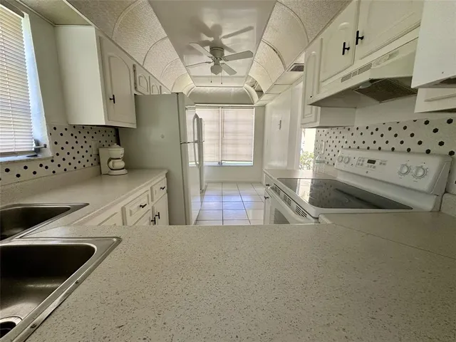 a kitchen with stainless steel appliances a sink a stove and a refrigerator