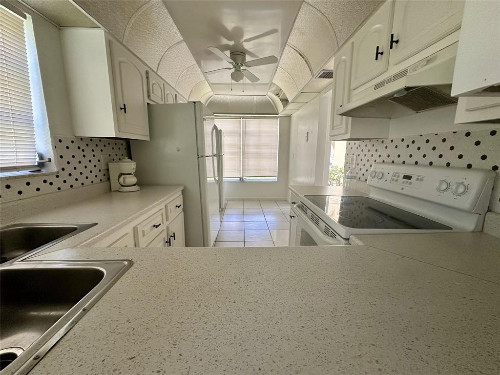 5980 Northwest 64th Avenue, Unit 112 Tamarac, FL 33319 - Photo 4 of 13 a kitchen with stainless steel appliances a sink a stove and a refrigerator