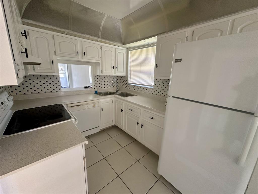 5980 Northwest 64th Avenue, Unit 112 Tamarac, FL 33319 - Photo 5 of 13 a kitchen with granite countertop white cabinets and white appliances