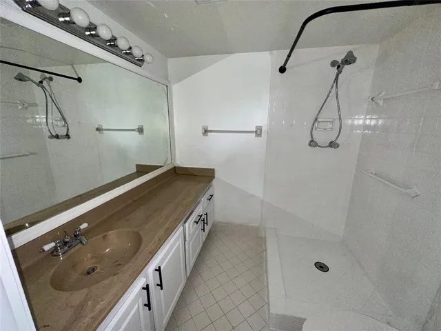 a bathroom with a double vanity sink a toilet and shower