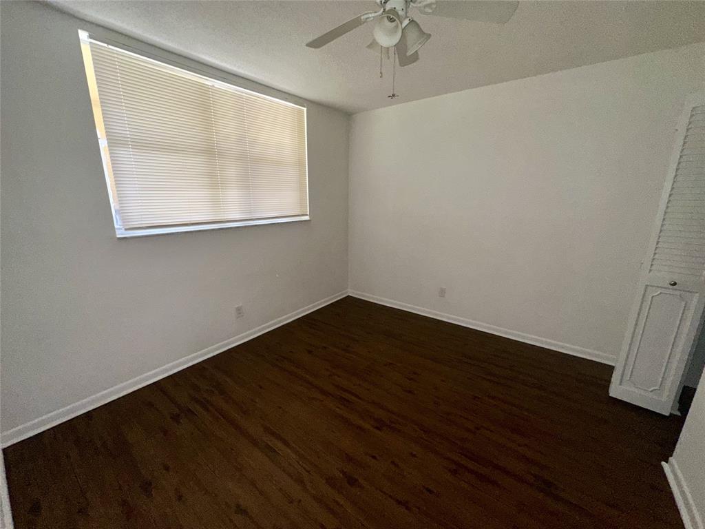 5980 Northwest 64th Avenue, Unit 112 Tamarac, FL 33319 - Photo 10 of 13 an empty room with wooden floor and windows