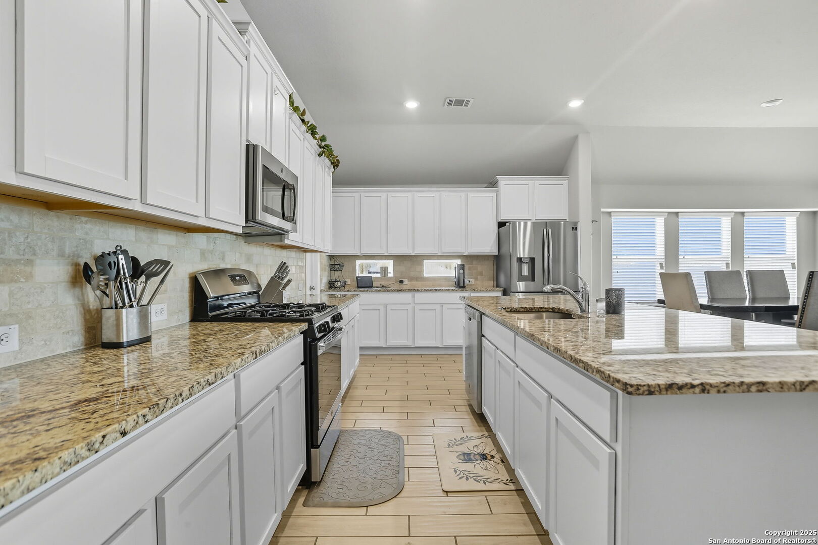 9825 Jon Boat Way Boerne, TX 78006 - Photo 7 of 24 a large kitchen with granite countertop a sink and dishwasher a stove top oven with wooden floor