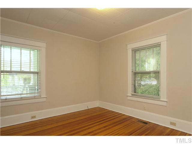 124 Hudson Street Raleigh, NC 27608 - Photo 11 of 19 an empty room with wooden floor and windows