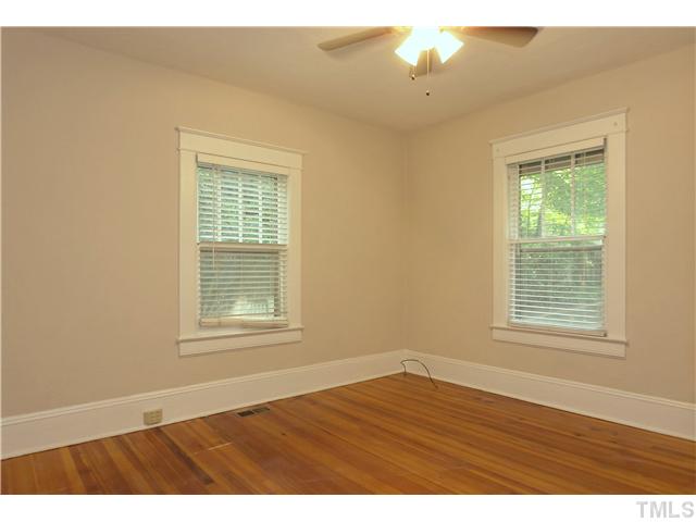 124 Hudson Street Raleigh, NC 27608 - Photo 12 of 19 an empty room with wooden floor and windows