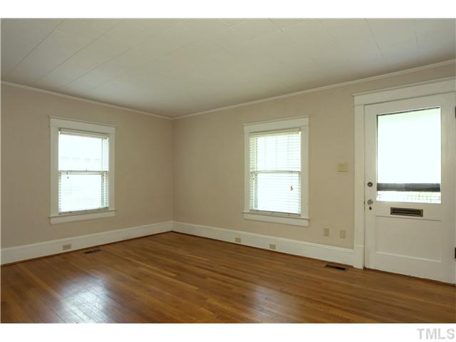 124 Hudson Street Raleigh, NC 27608 - Photo 3 of 19 an empty room with wooden floor and windows