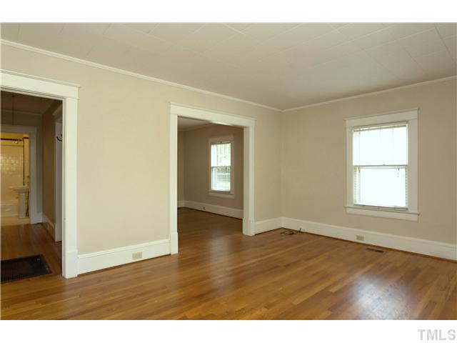 124 Hudson Street Raleigh, NC 27608 - Photo 5 of 19 an empty room with wooden floor and windows